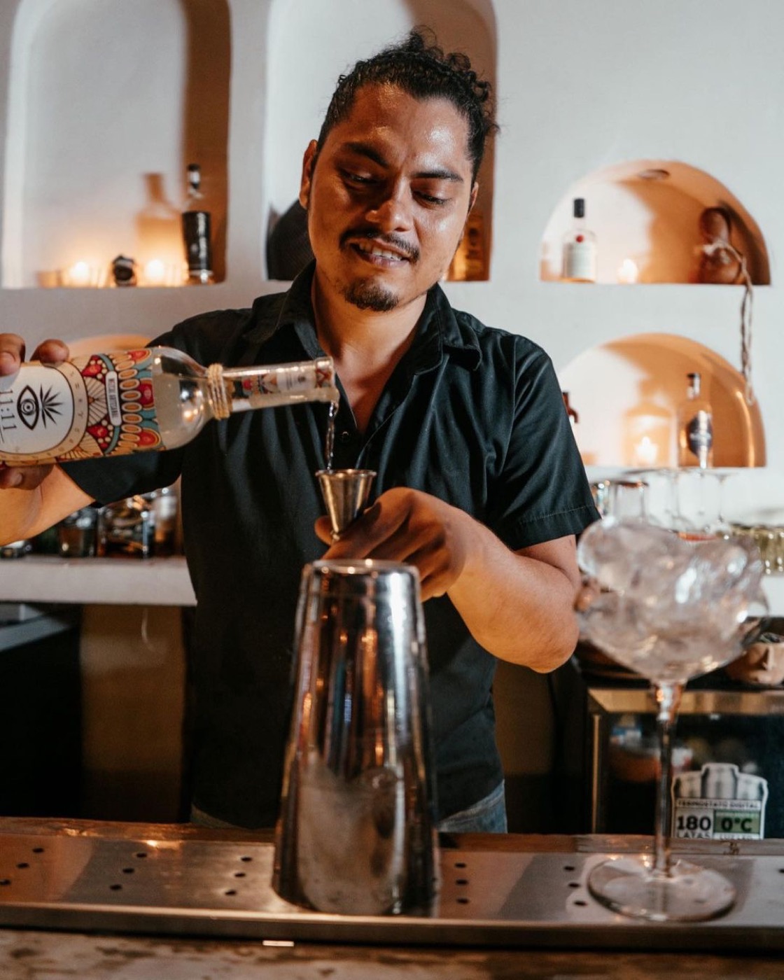 Bartender sirviendo Mezcal 11:11 Conexión en la barra